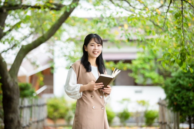 外で読書する女性