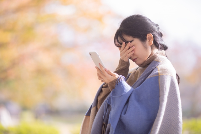 スマホを見て泣く女性