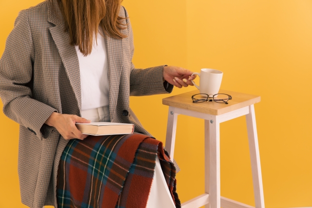 読書しながらコーヒーを飲む女性