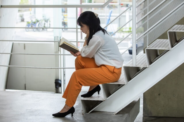 階段に座って読書する女性
