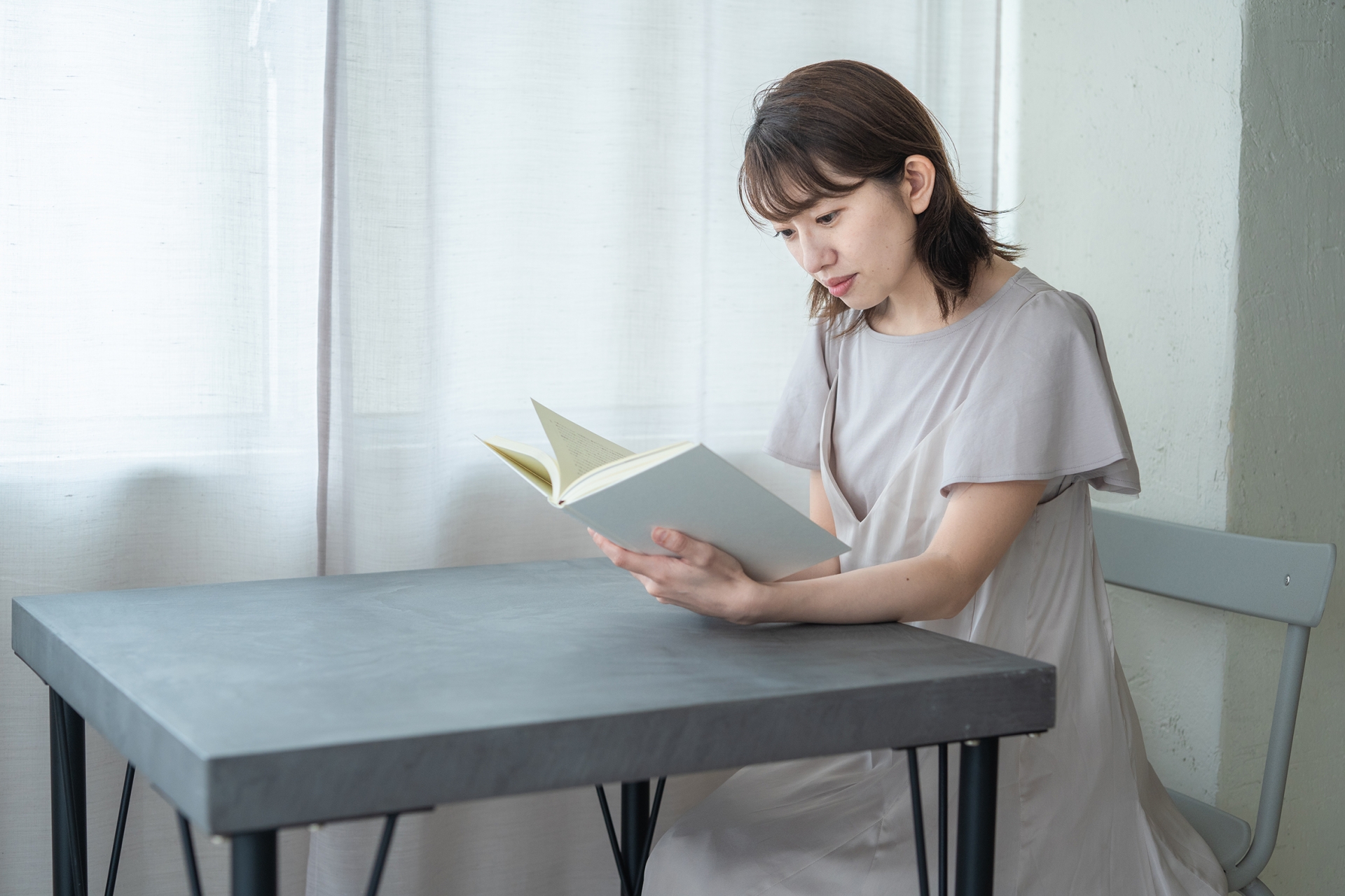 窓際で読書する女性