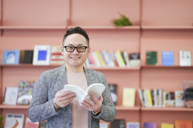 オレンジのオフィスで本を読む男性