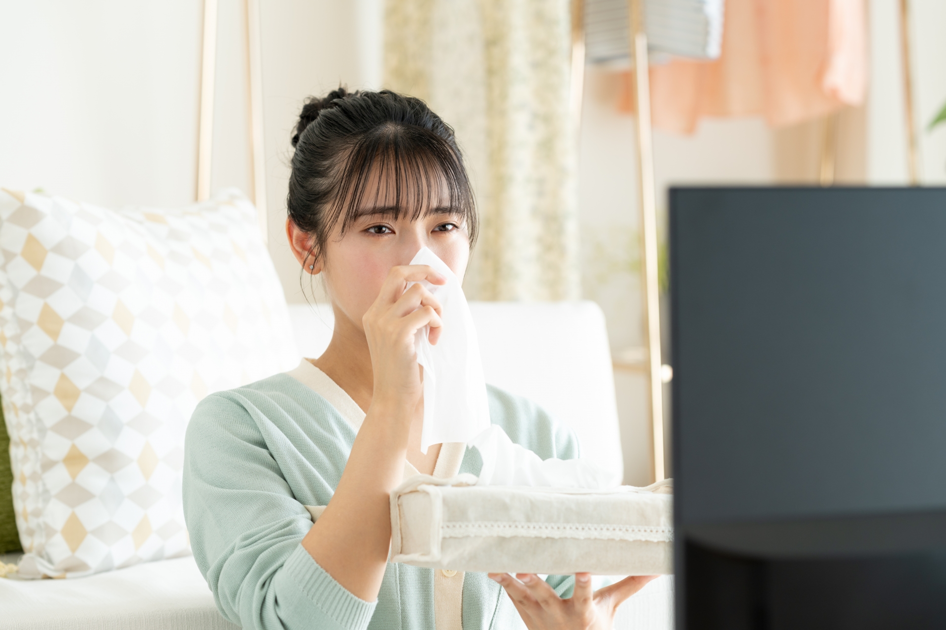 テレビを見て感動する若い女性