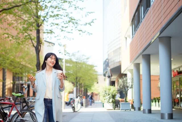 スマートフォンで音楽を聞きながら歩く日本人女性