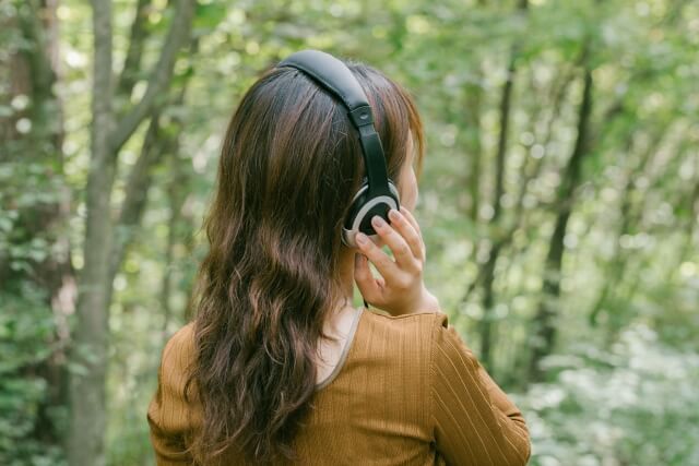森林の中で音楽を楽しむ女性