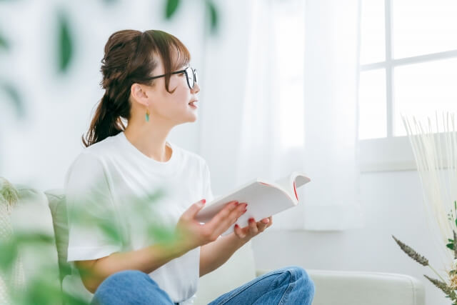 メガネをかけて本を読むアジア人女性