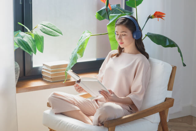 音楽を聴きながら読書する女性