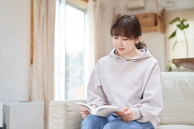 自宅で本を読むアジア人女性