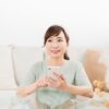 家でスマホを使う笑顔の日本人女性