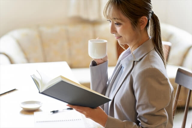コーヒーを飲みながら読書をする女性