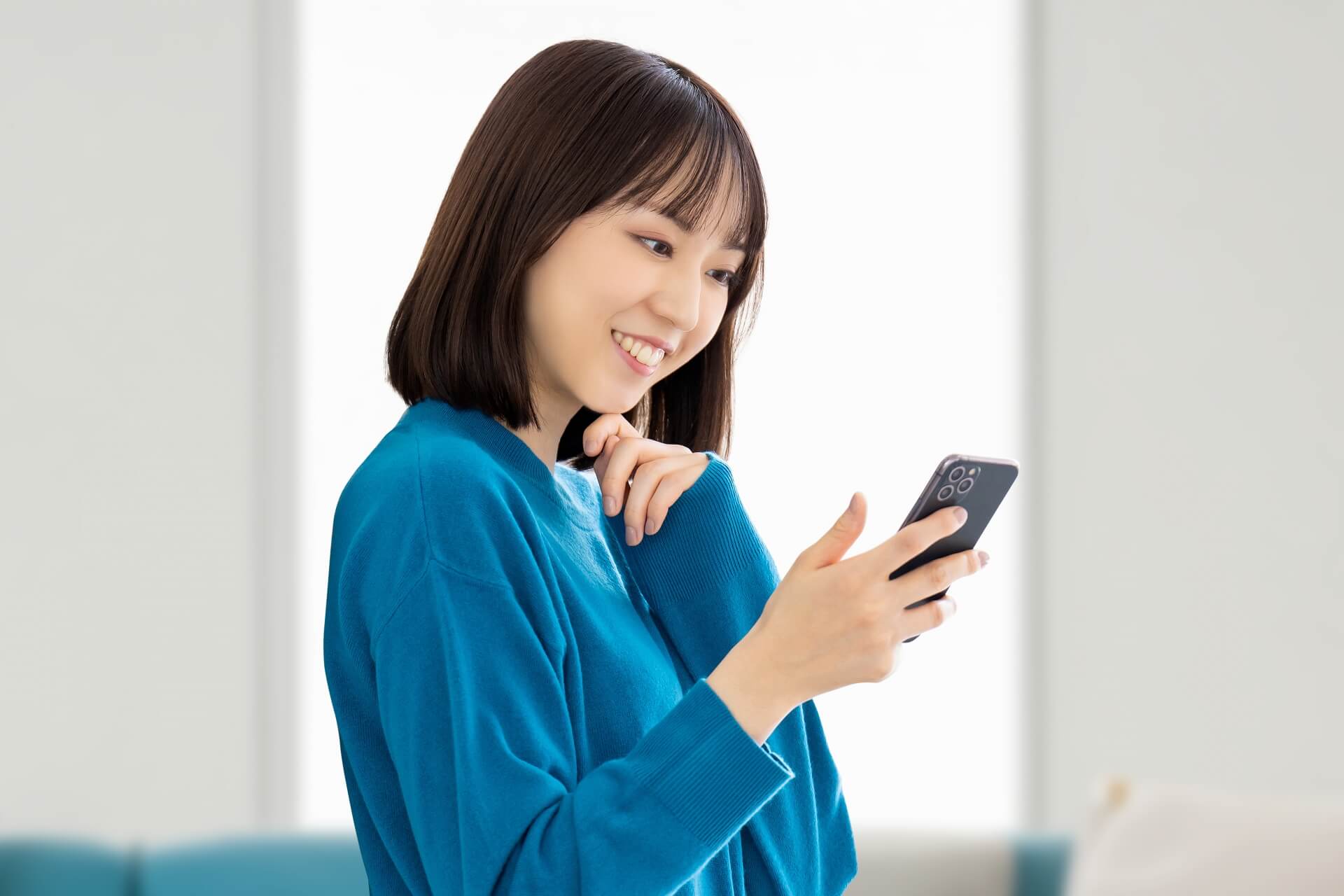 笑顔でスマホを見る若い女性